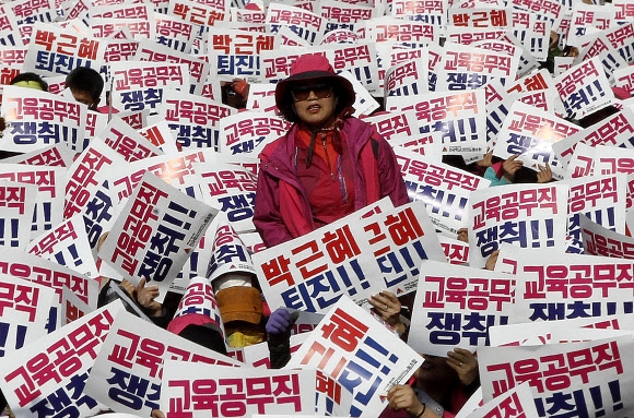 12일 오후 서울에서 열린 박근혜 대통령 퇴진을 촉구하는 집회에서 참가자들이 피켓을 들고 구호를 외치고 있다.<br>AP 연합뉴스