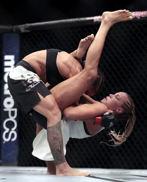 Liz Carmouche(왼쪽)이 미국 뉴욕 매디슨 스퀘어 가든에서 열린 ‘UFC 205 종합 격투기’ 여자 밴텀급 경기에서 Katlyn Chookagian을 들고 있다. AP 연합뉴스