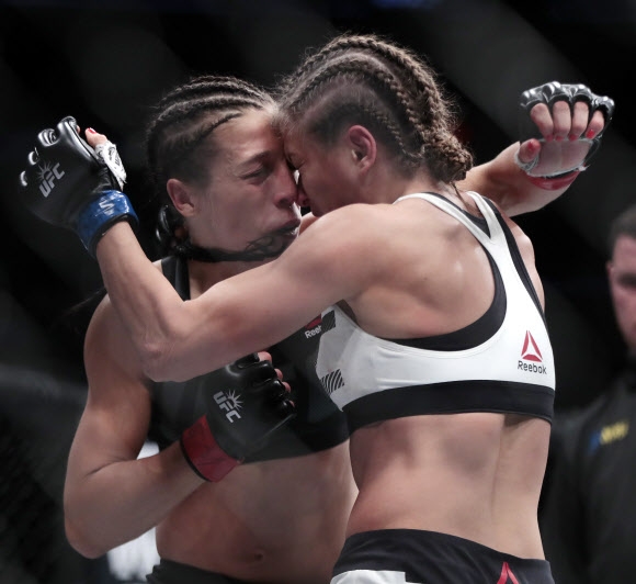 Karolina Kowalkiewicz(오른쪽)와 Joanna Jedrzejczyk이 12일(현지시간) 미국 뉴욕 매디슨 스퀘어 가든에서 열린 ‘UFC 205 종합 격투기’ 여자 스트로급 경기에서 서로의 얼굴이 밀착되고 있다. AP 연합뉴스