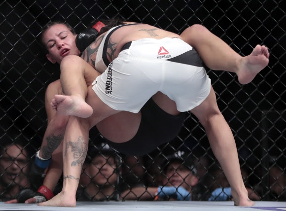 Raquel Pennington(앞)이 12일(현지시간) 미국 뉴욕 매디슨 스퀘어 가든에서 열린 ‘UFC 205 종합 격투기’ 여자 밴텀급 경기에서 Miesha Tate를 들고 있다. AP 연합뉴스