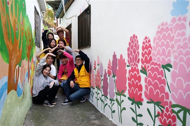 서울 성동구 마장동 담벼락을 예쁜 그림으로 꾸미는 ‘마장동 벽화프로젝트’를 마친 자원봉사자들이 기념사진을 찍고 있다. 성동구 제공
