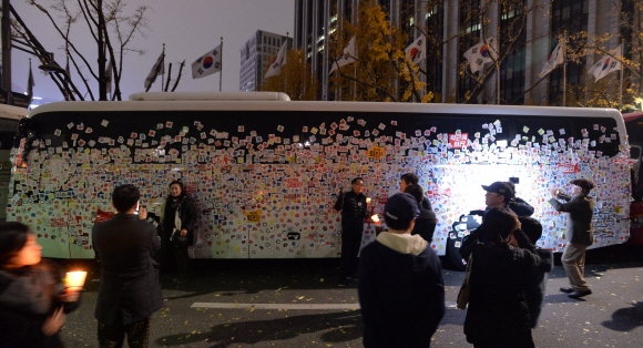 19일 오후 박근혜 대통령 퇴진 촉구 제4차 촛불집회가 열린 서울 광화문 일대에 차벽을 만들기 위해서 세워놓은 경찰 버스가 시민들이 붙인 스티커로 덮여 있다.  손형준 기자 boltagoo@seoul.co.kr