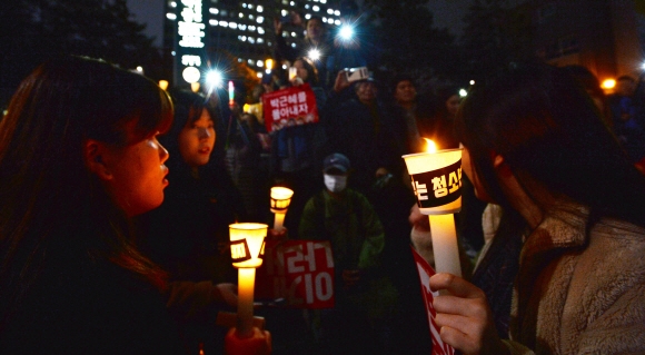 19일 오후 제4차 촛불집회에 참가한 청소년들이 청와대로 가는 길목인 서울 종로구 내자동로터리 앞에 모여 박근혜 대통령 퇴진을 촉구하며 촛불을 들고 서 있다.  손형준 기자 boltagoo@seoul.co.kr