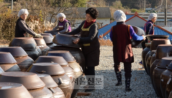 직원이 옹기 뚜껑을 들고 걸어가고 있다. 논산 이언탁 기자 utl@seoul.co.kr