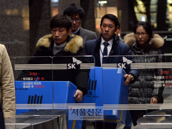 24일 검찰 관계자들이 중구 서린동 SK본사에서 압수품을 박스에 담아 들고 나오고 있다. 박지환 기자 popocar@seoul.co.kr