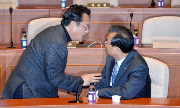 새누리당 이정현 대표(오른쪽)와 정진석 원내대표가 25일 국회에서 열린 의원총회에서 이야기를 나누고 있다. 이종원 선임기자 jongwon@seoul.co.kr