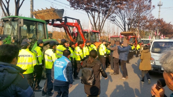 트랙터 놓고 대치하는 농민과 경찰관