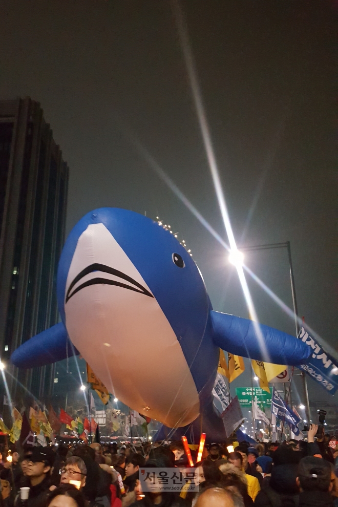 26일 저녁 서울 광화문광장 일대에서 제5차 촛불집회가 열린 가운데 세월호 참사 아이들을 상징하는 푸른 고래가 시위대를 수호하듯 시위대 아래 떠 있다. 고래 풍선은 세월호 참사 유가족들이 마련한 것이다. 김희리 기자 hitit@seoul.co.kr