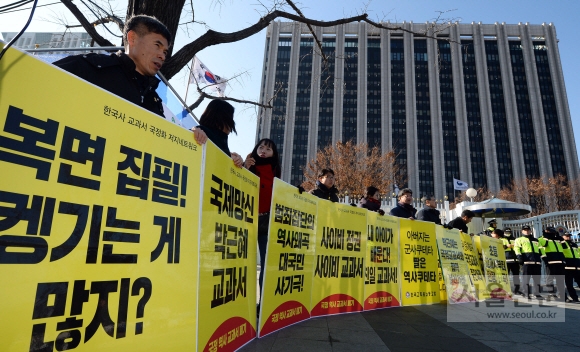 역사 국정교과서 현장검토본 공개 기자회견이 열린 28일 서울 세종로 정부서울청사 정문 앞에서 전교조 회원들이 국정화 중단을 촉구하는 문구를 들고 항의에 나섰다. 박윤슬 기자 seul@seoul.co.kr