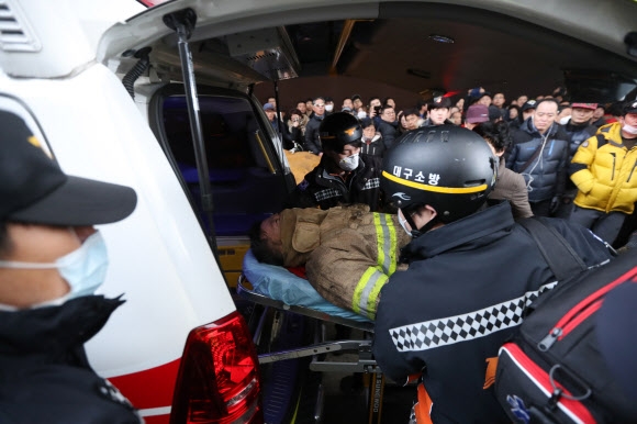 30일 오전 화재가 발생한 대구시 중구 서문시장에서 화재 진압을 하던 한 소방관이 다쳐 병원으로 이송되고 있다. 연합뉴스