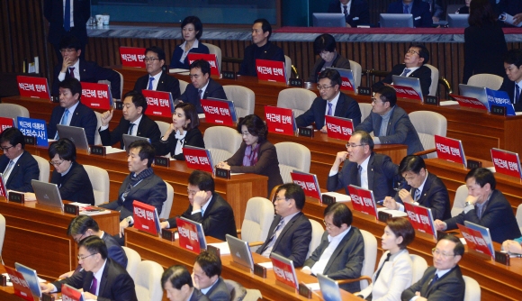 8일 서울 여의도 국회에서 열린 제 346회 국회 본회의에서 더불어민주당 의원들이 박근혜탄핵이라고 적힌 손팻말을 붙여 놓고 있다.   정연호 기자 tpgod@seoul.co.kr