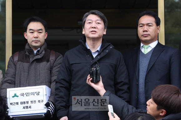 국민의당 안철수 전 대표(가운데)가 12일 오전 ’박근혜 대통령 퇴진’을 요구하는 국민 21만명의 서명을 헌법재판소에 전달하기에 앞서 취재진의 질문에 답하고 있다. 이언탁 기자 utl@seoul.co.kr