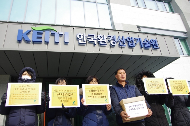 김포 환경피해지역 주민대표 초원지3리 이장(왼쪽 네 번째)과 환경전문가들이 서울시 은평구 한국환경산업기술원 정문 앞에서 구제급여 신청서류를 들고 기념사진을 찍고 있다. ‘환경정의’ 제공 