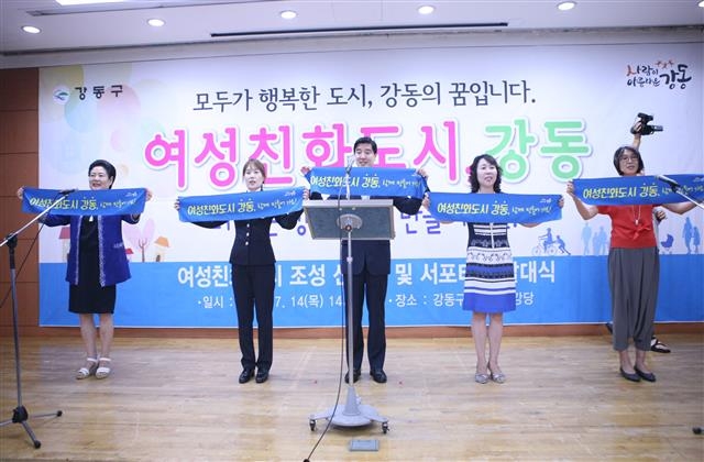 이해식(가운데) 강동구청장이 지난 7월 여성친화도시 조성 선포식 및 서포터스 발대식에 참여해 ‘여성친화도시 강동, 함께 만들어 가요’라고 적힌 플래카드를 펼쳐 보이고 있다. 강동구 제공