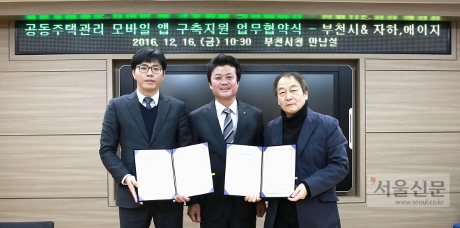 김만수(가운데) 부천시장이 지난 16일 정동영(왼쪽) 에이지스마트 대표, 강휘석 자하스마트 이사와 함께 업무협약을 체결한 뒤 협약서를 보여주고 있다. 부천시 제공 