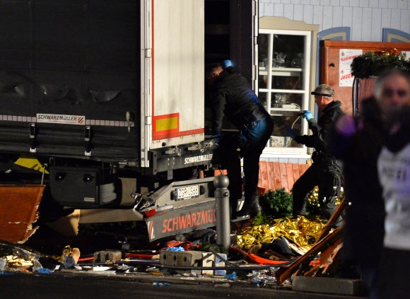 독일 경찰들이 베를린 카이저 빌헬름 메모리얼 교회 근처 크리스마스 마켓에서 19일 오후 8시14분쯤(현지시간) 발생한 트럭테러에 쓰인 트럭을 수색하고 있다. AFP 연합뉴스
