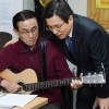 [서울포토] “기타 잘 치시네요”… 어르신 연주 듣는 황교안 권한대행