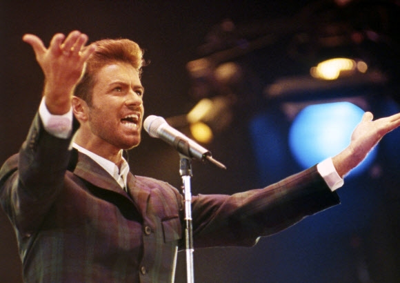 25일(이하 현지시간) 53세를 일기로 세상을 떠난 영국의 팝스타 조지 마이클이 1993년 12월 2일 런던 웸블리 구장에서 열린 세계 에이즈의 날 제정을 기념한 ´콘서트 오브 호프´ 도중 공연에 열중하고 있다. AP 자료사진 