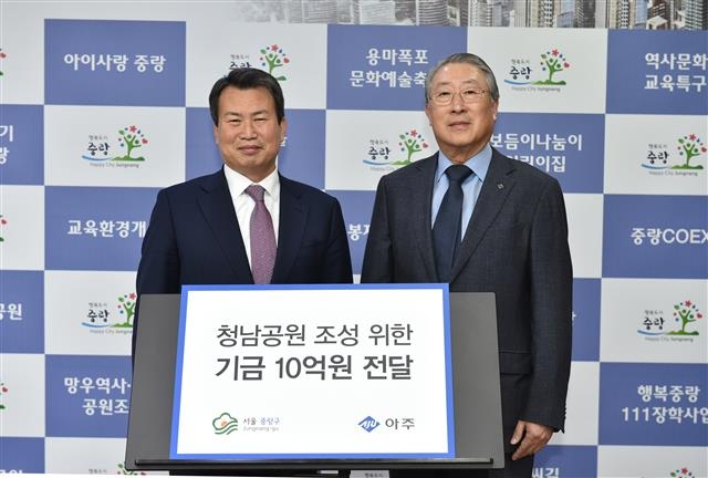 나진구(왼쪽) 서울 중랑구청장이 지난 28일 구청 집무실에서 문규영 아주그룹 회장으로부터 기금 10억원을 전달받은 뒤 포즈를 취하고 있다. 중랑구 제공