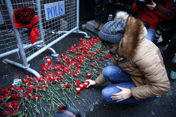 나이트클럽 입구에 설치된 경찰 바리케이드에 한 주민이 희생자를 추모하기 위한 꽃과 촛불을 놓고 있는 모습. 이스탄불 EPA 연합뉴스