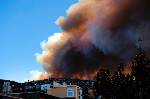 2일(현지시간) 칠레 중서부 항구도시 발파라이소 인근 숲에서 화염과 연기가 치솟고 있다. AFP 연합뉴스