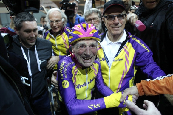 프랑스의 105세 어르신 로베르 마르샹이 4일(현지시간) 파리 근처 생 퀑땅 엉 이블린느 벨로드롬에서 한 시간 동안 가장 먼 거리를 주파한 기록을 세운 뒤 열렬한 환영에 답하고 있다.  생 퀑땅 엉 이블린느 AP 연합뉴스 