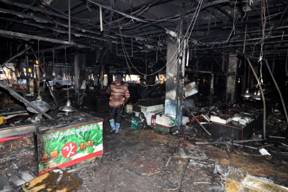 한 상인이 15일 대형 화재로 폐허가 된 전남 여수시 교동 수산시장 내부를 둘러보고 있다. 이날 사고로 시장 1층의 점포 116곳이 불에 탔다. 여수 연합뉴스
