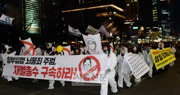 지난 14일 밤 서울 광화문광장 일대에서 열린 12차 촛불집회에서 참가자들이 겨울 한파에도 불구하고 재벌 개혁을 외치며 행진하고 있다. 강성남 선임기자 snk@seoul.co.kr