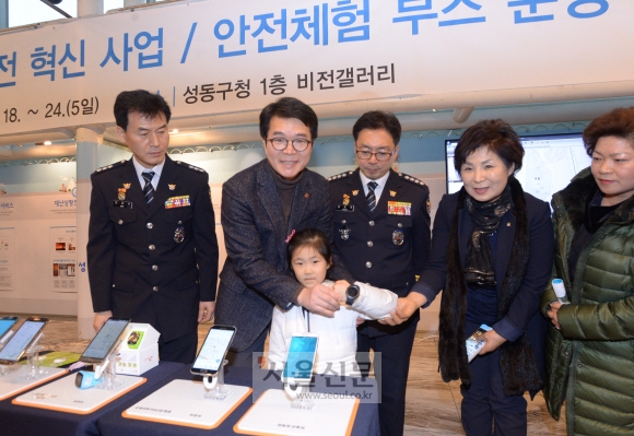 정원오(왼쪽 두 번째) 서울 성동구청장이 19일 구청 1층 로비에 설치된 ‘안전체험 부스’에서 한 어린이에게 시계를 채워 주며 ‘웨어러블 안심단말기’가 어떻게 작동하는지 설명하고 있다. 최해국 선임기자 seaworld@seoul.co.kr