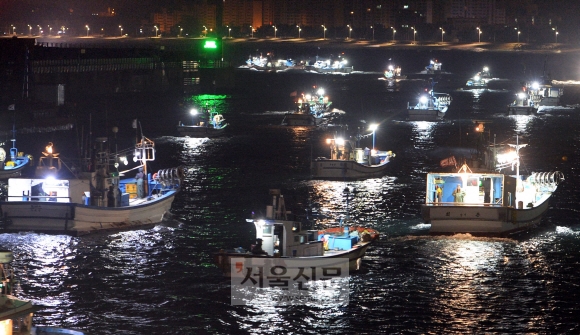 강원 강릉시 주문진항에서 새벽 3시 40분이 되자 불을 밝힌 어선들이 일제히 출항하고 있다.