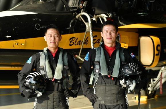 공군 특수비행팀 ‘블랙이글스’의 첫 형제 조종사인 53특수비행전대 239특수비행대대 강성현(오른쪽) 소령과 강성용 대위가 자신들이 조종하는 T50B 항공기 앞에서 포즈를 잡고 있다. 공군 제공
