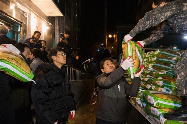 김영배 성북구청장이 지난 1월 어려운 이웃을 위해 7년째 매해 쌀 300포를 기부하고 있는 월곡2동 얼굴 없는 천사가 보낸 쌀을 나르고 있다.