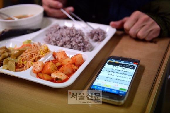 서울 광화문의 한 회사 구내식당에서 퀵서비스 기사 이모씨가 콜신호가 오는 휴대전화를 옆에 두고 혼자서 급하게 식사를 하고 있다. 정연호 기자 tpgod@seoul.co.kr