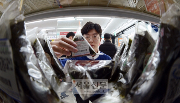 서울 강남의 GS25 편의점에서 직장인 정희철씨가 점심에 먹을 삼각김밥을 고르고 있다. 정연호 기자 tpgod@seoul.co.kr