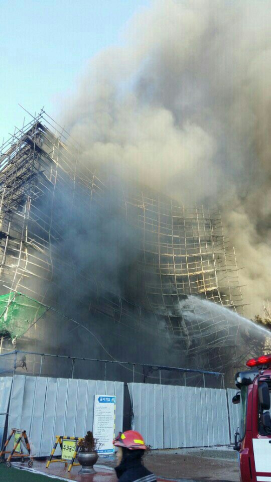 12일 오후 3시 50분쯤 부산 수영구 한바다중학교 내 증축공사 현장에서 불이나 검은 연기가 치솟고 있다.  부산소방본부 제공 