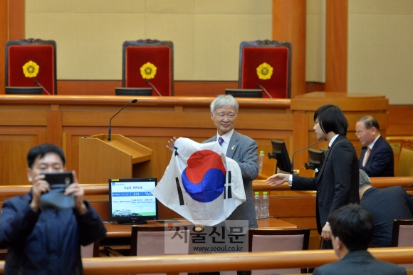 14일 오전 서울 종로구 재동 헌법재판소에서 열린 박근혜 대통령 탄핵심판 13차 변론에서 서석구 대통령 변호인이 태극기를 펼쳐보이다 직원에게 주의를 받고있다. 손형준 기자 boltagoo@seoul.co.kr