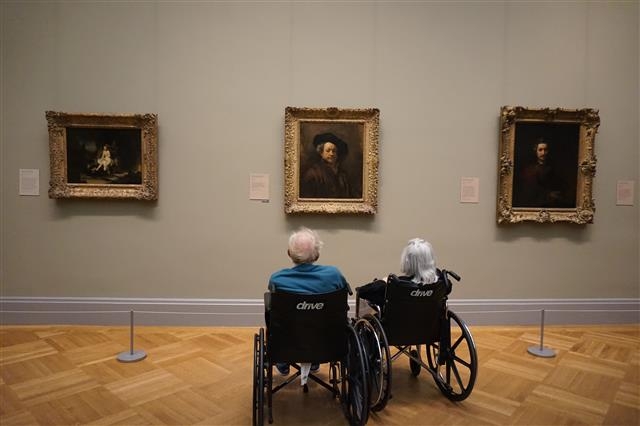 미술관에서 휠체어에 탄 노부부가 렘브란트의 자화상을 감상하고 있는 모습이 감동적이다.
