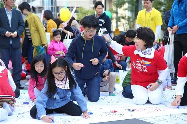 지난해 10월 서리풀 페스티벌에서 조 구청장이 지역 어린이들과 함께 반포대로에 그림을 그리고 있다. 서초구 제공