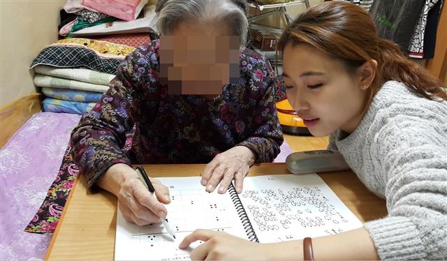 지난해 11월 서울 동작구 치매 전문 자원봉사 모임인 ‘동치미’ 소속의 한 봉사자가 노인을 상대로 인지향상 교육을 하고 있다. 동작구 제공