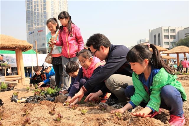 정원오 성동구청장이 무지개텃밭에서 어린이들과 함께 모종을 심고 있다. 성동구 제공