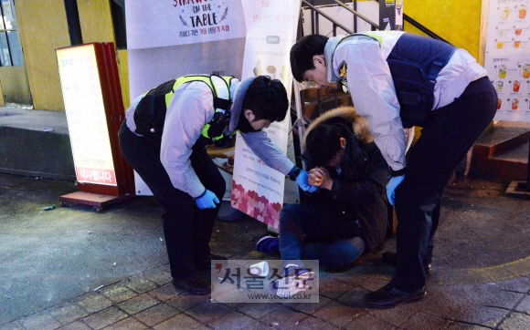 18일 새벽 시민의 신고를 받고 출동한 홍익지구대 소속 경찰들이 술에 취해 길거리에 쓰러져 있는 행인의 상태를 확인하고 있다. 손형준 기자 boltagoo@seoul.co.kr