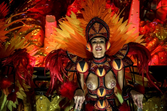 26일(현지시간) 브라질 리우데자네이루 삼보드로무에서 열린 카니발 퍼레이드에서 삼바 공연팀의 댄서가 화려한 의상을 입고 춤을 선보이고 있다. EPA 연합뉴스