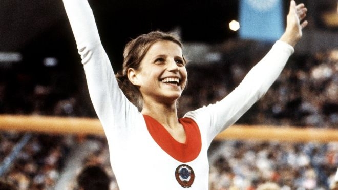 1972년 뮌헨올림픽 체조 금메달을 목에 걸고 관중에 답례하는 올가 코르부트.  AP 자료사진 