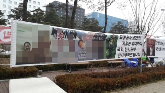 국회 앞에 걸려 있는 ‘표창원 부부 성적 묘사’ 현수막