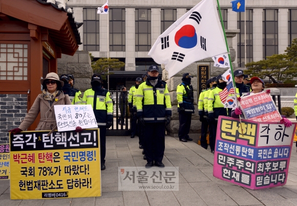 헌법재판소의 박근혜 대통령 탄핵심판 선고가 임박한 가운데 8일 서울 종로구 재동 헌재 정문 앞에서 각각 탄핵 인용과 각하를 주장하는 손팻말을 든 시민들이 1인 시위를 하고 있다. 박지환 기자 popocar@seoul.co.kr