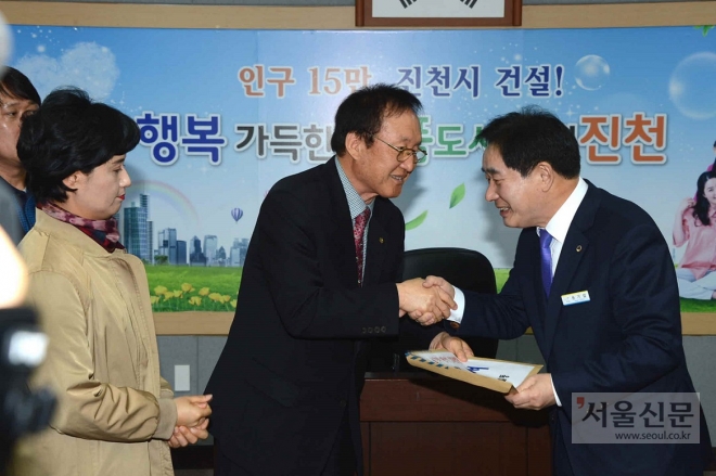 증평군민들이 13일 송기섭(오른쪽) 진천군수에게 돈사 이전 반대 진정서를 전달하고 있다. 증평군 제공 