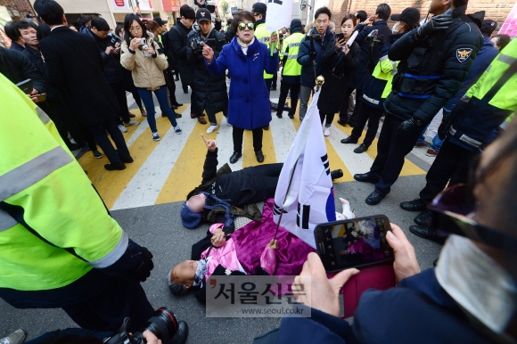 14일 서울 삼성동 박근혜 전 대통령 자택 앞에서 박근혜 전 대통령 지지자들이 도로에 누워 언론차 취재차량의 통행을 방해하고 있다. 정연호 기자 tpgod@seoul.co.kr