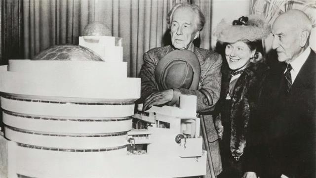 구겐하임 미술관의 건축을 위한 첫 프레젠테이션 당시 프랭크 로이드 라이트(왼쪽)가 힐러 리베이, 솔로몬 구겐하임과 함께 미술관 모형을 바라보고 있다.