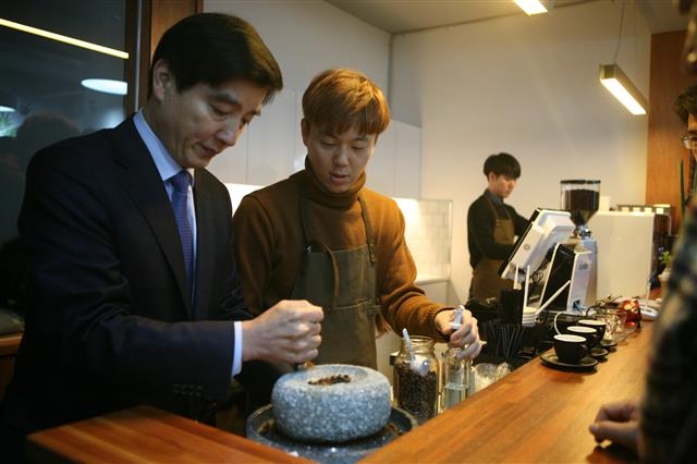 이 구청장(왼쪽)이 ‘승룡이네집’(지역공동체 시설)에 입점한 카페에서 맷돌로 커피를 갈고 있다. 강동구 제공