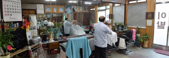 70여년째 한자리를 지키며 옛 이발소의 모습을 그대로 간직한 서울의 한 이발소에서 노년의 이발사가 노신사의 머리를 자르고 있다.